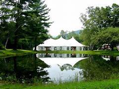 Outdoor event tent setup beside a reflective pond, representing professional event environments supported by Ultimate Textile